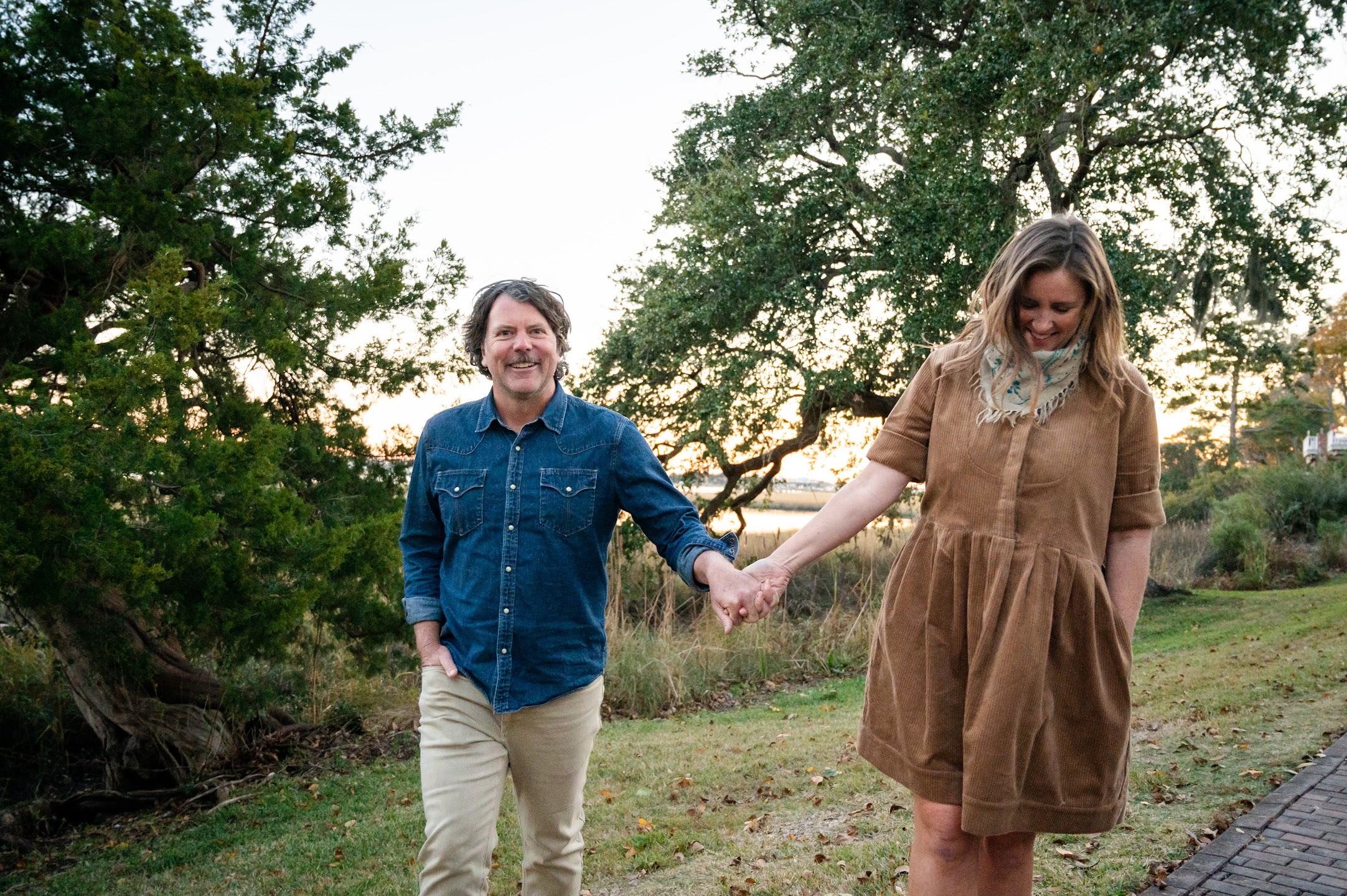 Chris and Anne walking hand in hand outdoors.